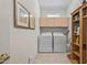 Well-lit laundry room with upper cabinets, tile flooring, framed art, and a washer and dryer at 15753 W Kino Dr, Surprise, AZ 85374