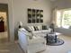 Bright living room featuring comfortable seating, modern art, and a view of the backyard at 15753 W Kino Dr, Surprise, AZ 85374