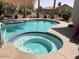 Inviting pool and spa with blue tile accents surrounded by a desert landscaped backyard at 15753 W Kino Dr, Surprise, AZ 85374