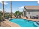 Beautiful blue pool and spa in backyard with desert landscaping, chairs and patio dining area at 15753 W Kino Dr, Surprise, AZ 85374