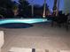 Night view of a stunning pool and jacuzzi surrounded by lush landscaping at 15753 W Kino Dr, Surprise, AZ 85374