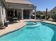 Relaxing pool area with a spa, patio seating, and lush landscaping at 15753 W Kino Dr, Surprise, AZ 85374