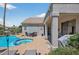 Inviting backyard with a sparkling blue pool, spa, covered patio, and desert landscaping at 15753 W Kino Dr, Surprise, AZ 85374