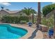 The sparkling pool is surrounded by lush landscaping, creating a serene outdoor oasis at 15753 W Kino Dr, Surprise, AZ 85374
