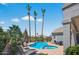 Inviting backyard pool with spa, lounge chairs, and tall palm trees for relaxing in the Arizona sun at 15753 W Kino Dr, Surprise, AZ 85374