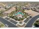 Aerial view of community center with palm trees, pool, parking, and golf course in the background at 15989 W Indianola Ave, Goodyear, AZ 85395