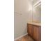 Half bathroom featuring vanity with wood cabinets, light countertops, and a decorative light fixture at 15989 W Indianola Ave, Goodyear, AZ 85395