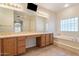 Bathroom with a soaking tub, a large mirror, and tile flooring at 15989 W Indianola Ave, Goodyear, AZ 85395
