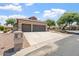 A house featuring a spacious concrete driveway leading to a three-car garage, framed by desert landscaping at 15989 W Indianola Ave, Goodyear, AZ 85395