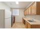 Functional laundry room features cabinets, sink, refrigerator, and modern washer and dryer units at 15989 W Indianola Ave, Goodyear, AZ 85395