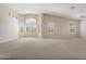 The airy living room features neutral walls, large windows, carpet, and vaulted ceilings, perfect for relaxing at 15989 W Indianola Ave, Goodyear, AZ 85395
