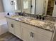 Bathroom featuring a double vanity with granite counters, white cabinetry, and modern black fixtures at 16006 W Electra Ln, Surprise, AZ 85387