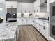 Beautiful kitchen featuring white cabinets, granite countertops, stainless steel appliances, and wood look flooring at 16006 W Electra Ln, Surprise, AZ 85387