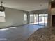 Spacious living area with tile flooring, sliding glass doors to the backyard, and view of the kitchen area at 16006 W Electra Ln, Surprise, AZ 85387