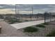 Outdoor pickleball court with black fencing, smooth pavement, and manicured gravel landscaping at 16006 W Electra Ln, Surprise, AZ 85387