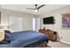 Cozy bedroom featuring a large bed, ceiling fan, and dresser with a mounted TV at 1639 W Indianola Ave, Phoenix, AZ 85015