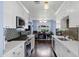 Clean kitchen with white cabinets, updated appliances, and quartz countertops with a view into a light-filled room at 1639 W Indianola Ave, Phoenix, AZ 85015