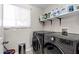 Well-lit laundry room with modern LG washer and dryer, plus storage shelving at 1639 W Indianola Ave, Phoenix, AZ 85015