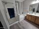 Bathroom with wood-look vinyl flooring, glass-enclosed shower, and double sink vanity at 17328 W Pinnacle Vista Dr Dr, Surprise, AZ 85387