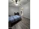 Bedroom featuring neutral gray walls, a glimpse of the ensuite bathroom, and wood-look vinyl flooring at 17328 W Pinnacle Vista Dr Dr, Surprise, AZ 85387