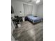 Bedroom with blue plaid bedding, desk area, wood-look vinyl flooring, and neutral gray walls at 17328 W Pinnacle Vista Dr Dr, Surprise, AZ 85387