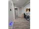 Hallway featuring gray walls and wood-look vinyl flooring, leading to a playroom with a playpen at 17328 W Pinnacle Vista Dr Dr, Surprise, AZ 85387