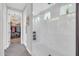 Bright bathroom featuring a glass-enclosed shower with white marble tile and small windows for natural light and a walk-in closet at 17815 W Straight Arrow Ln, Surprise, AZ 85387