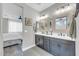 Well-lit bathroom featuring double sinks, framed mirrors, and modern fixtures at 17815 W Straight Arrow Ln, Surprise, AZ 85387
