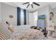 Comfortable bedroom with ceiling fan, blue curtains, and bed with patterned bedding, offering a cozy and inviting space at 17815 W Straight Arrow Ln, Surprise, AZ 85387