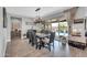 Stylish dining room featuring a modern chandelier, wood floors, and sliding glass doors to the backyard pool at 17815 W Straight Arrow Ln, Surprise, AZ 85387