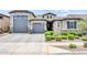 Charming single-story home with a well-manicured front yard, complemented by a gray exterior and three-car garage at 17815 W Straight Arrow Ln, Surprise, AZ 85387