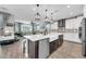 A modern kitchen includes an island with bar seating, stainless steel appliances and pendant lighting at 17815 W Straight Arrow Ln, Surprise, AZ 85387