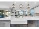 Large kitchen island with white countertops and built-in farmhouse sink at 17815 W Straight Arrow Ln, Surprise, AZ 85387
