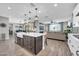 Open-concept kitchen island transitions into a comfortable, sun-lit living area at 17815 W Straight Arrow Ln, Surprise, AZ 85387