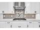 The kitchen features stainless steel appliances and custom tile backsplash at 17815 W Straight Arrow Ln, Surprise, AZ 85387