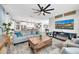 An open concept living room features a modern ceiling fan, fireplace, and desert artwork on display at 17815 W Straight Arrow Ln, Surprise, AZ 85387