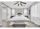 Well-lit main bedroom features a comfortable bed, barn-door bathroom access, and neutral decor at 17815 W Straight Arrow Ln, Surprise, AZ 85387