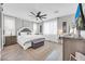 A bright main bedroom showcases a ceiling fan, ensuite bathroom, decorative rug and bedside tables at 17815 W Straight Arrow Ln, Surprise, AZ 85387