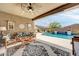 Covered patio boasting stylish seating, ceiling fan, and views of the refreshing pool at 17815 W Straight Arrow Ln, Surprise, AZ 85387