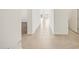 Bright hallway featuring neutral tile flooring, white walls, and views to other rooms at 19152 N Bandin Dr, Maricopa, AZ 85138