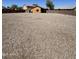 A large fenced-in backyard with low-maintenance gravel landscaping and a small covered patio at 20761 N Herbert Ave, Maricopa, AZ 85138