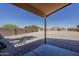 Covered patio extends to the gravel backyard, fenced for privacy at 20761 N Herbert Ave, Maricopa, AZ 85138