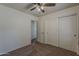 Bedroom with neutral colored carpet, a ceiling fan, closet, and an open door at 20761 N Herbert Ave, Maricopa, AZ 85138