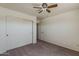 Carpeted bedroom with mirrored closet doors and ensuite bathroom at 20761 N Herbert Ave, Maricopa, AZ 85138