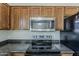 Close-up of modern stainless steel microwave and electric range against a light backsplash at 20761 N Herbert Ave, Maricopa, AZ 85138
