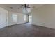 Spacious living room with vaulted ceiling, ceiling fan, two windows and a sliding glass door at 20761 N Herbert Ave, Maricopa, AZ 85138