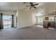 Open concept living room flowing into a kitchen area with vaulted ceiling and sliding glass door at 20761 N Herbert Ave, Maricopa, AZ 85138