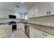 Updated kitchen features granite countertops, stainless steel appliances, and white cabinetry at 2148 W Hayward Ave, Phoenix, AZ 85021