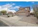 Exterior view of a two-story home with a spacious driveway and desert landscaping at 22672 W Solano Dr, Buckeye, AZ 85326