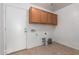 Functional laundry room with tile flooring and light brown cabinets for ample storage space at 22672 W Solano Dr, Buckeye, AZ 85326